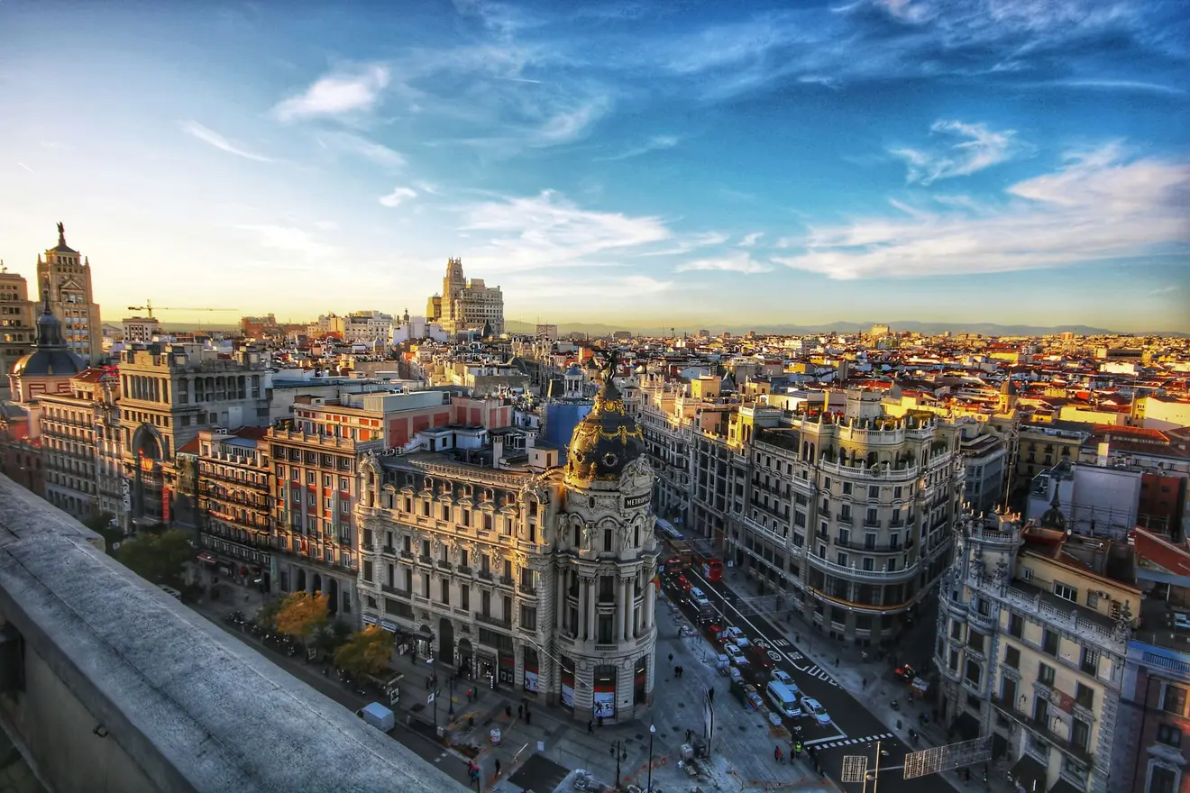 Madrid's Gran Vía and the Metropolis building at dusk: since April 2025 no amount of Spanish property buys a residence permit, and the four routes that remain each ask for something other than capital